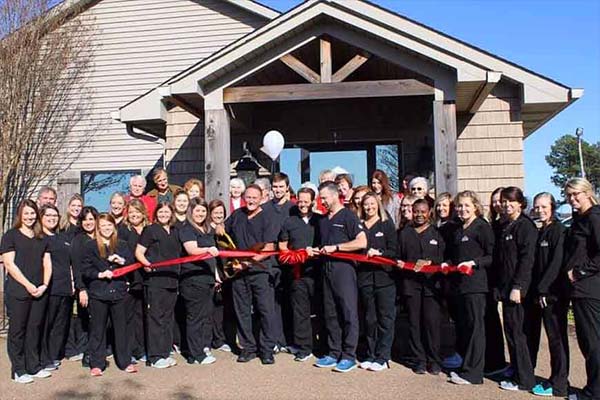 Two Premier Dental team members posing for ribbon cutting