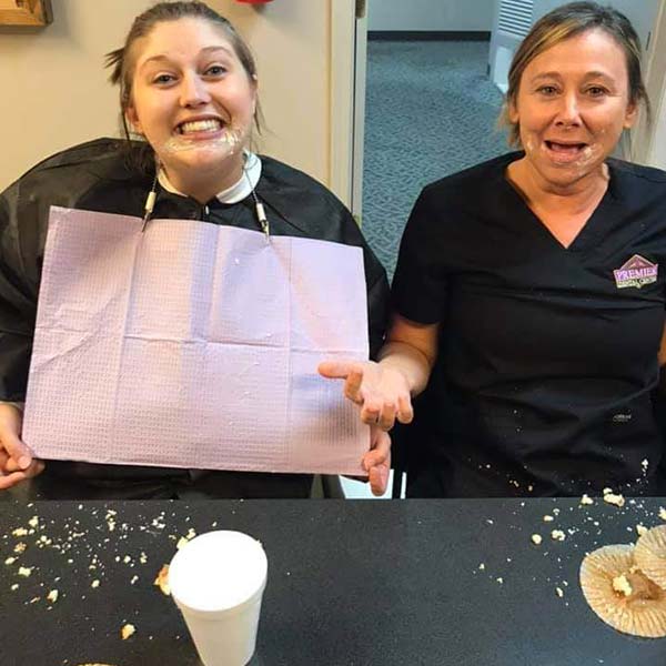 Two Premier Dental Center team members posing after eating competition