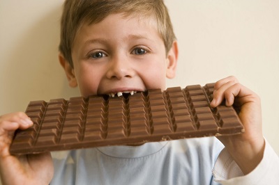 boy eating a big bar of chocolate