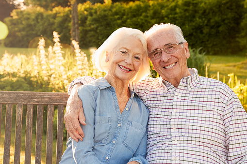 smiling senior couple sitting on bench