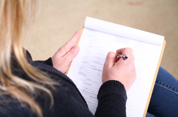 Woman filling out insurance paperwork at Premier Dental Center in Jackson, Bells, & Milan, TN