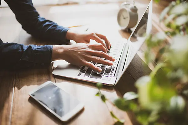 Hands typing at a laptop