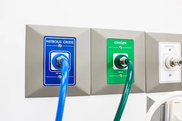 Wall-mounted nitrous oxide and oxygen outlets used for sedation dentistry in a dental office.